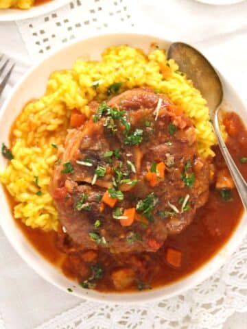 slow cooker ossobuco served with risotto milanese and gremolata.