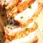 pork belly in the slow cooker with very crispy crackling sliced on a wooden board.