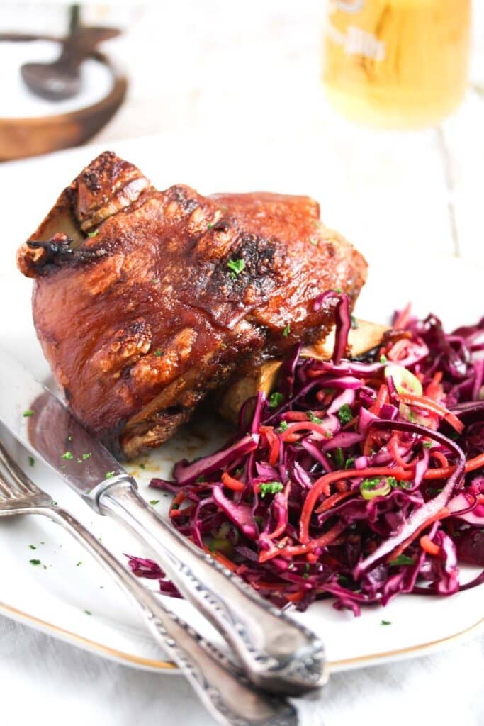 serving german pork knuckles with red cabbage and beer.