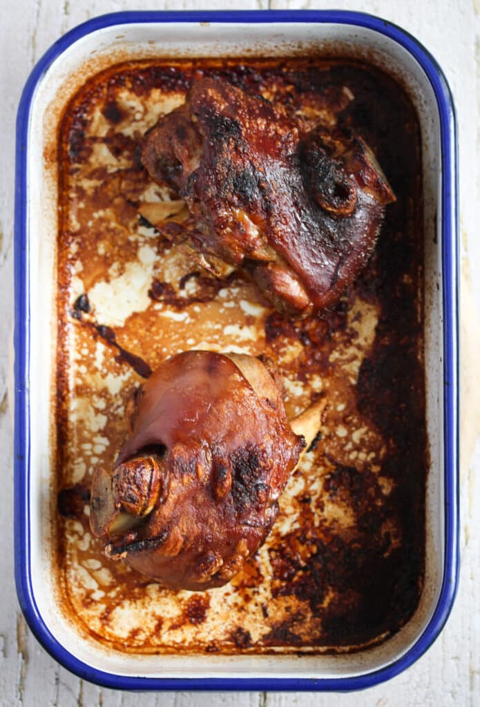 two pork hocks in a roasting tin.