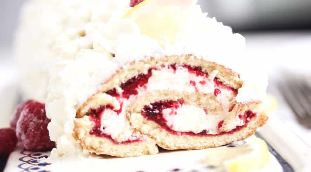 close up cut roulade with raspberry and lemon.