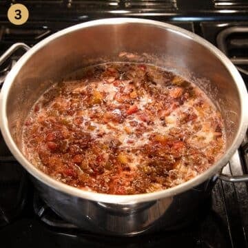 cooking jam with rhubarb and strawberries in a pot.