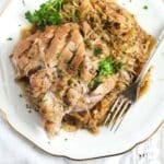 pinterest image of a plate with pork meat and sauerkraut with title underneath.