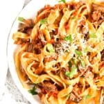 pinterest image of slow cooker lamb ragu served with pappardelle.