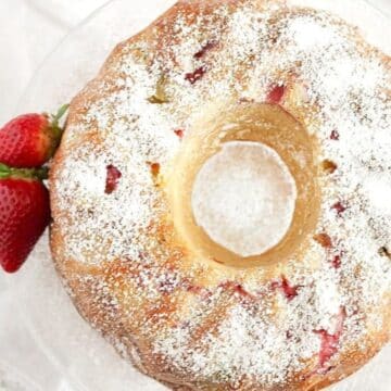 bundt cake with rhubarb and a few strawberries around it.