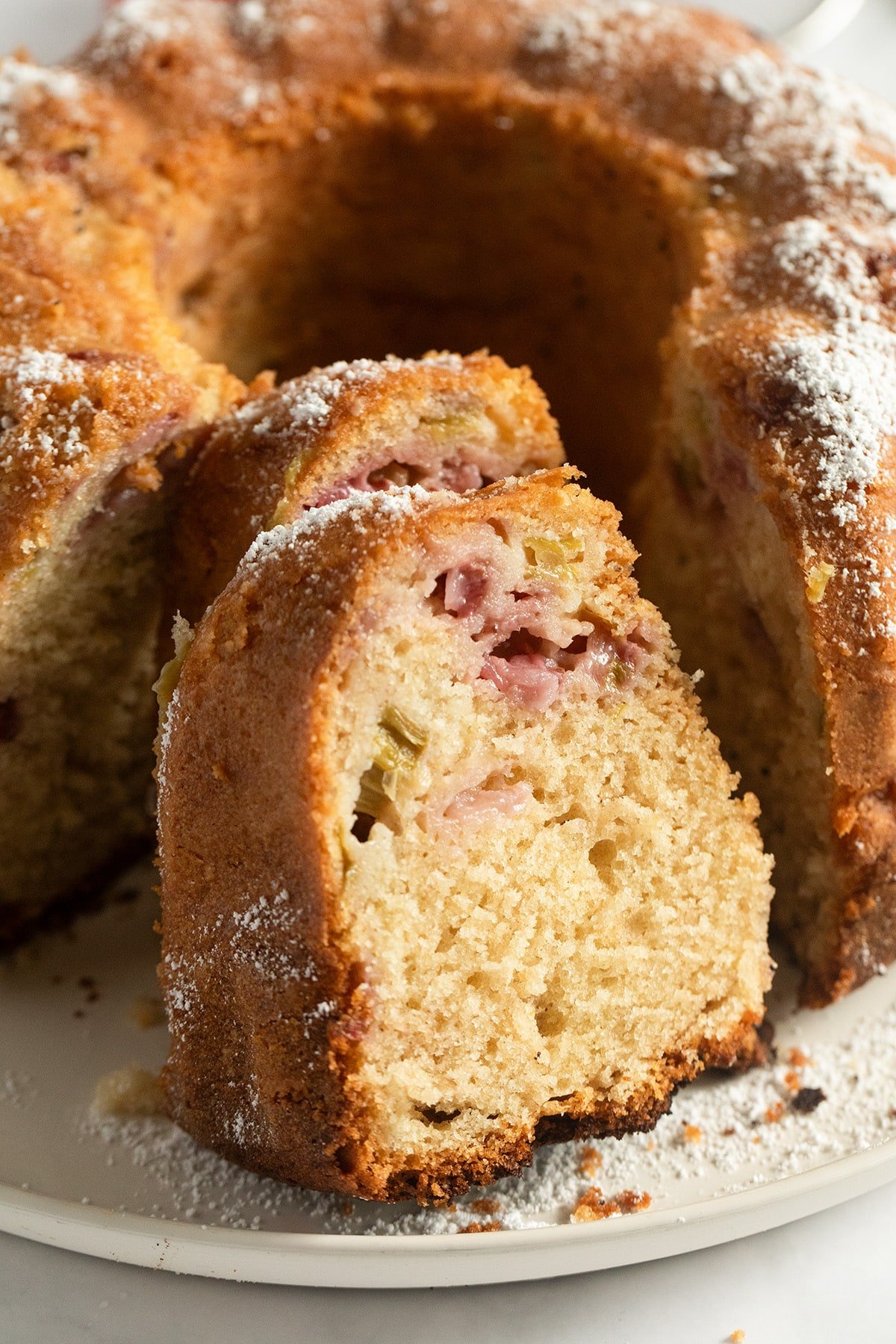 sliced rhubarb strawberry bundt cake on a platter.