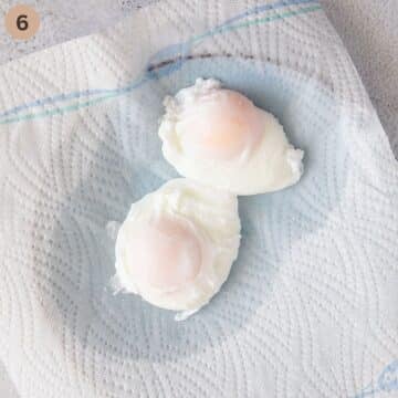 two poached eggs draining on paper towels.