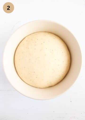 risen dough in a bowl for making wild garlic bread.