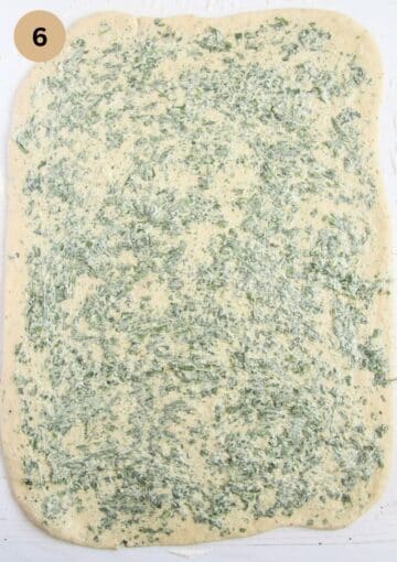 large piece of bread dough spread with wild garlic butter.