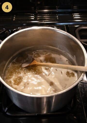 stirring cooking elderflower jam in a large pot.