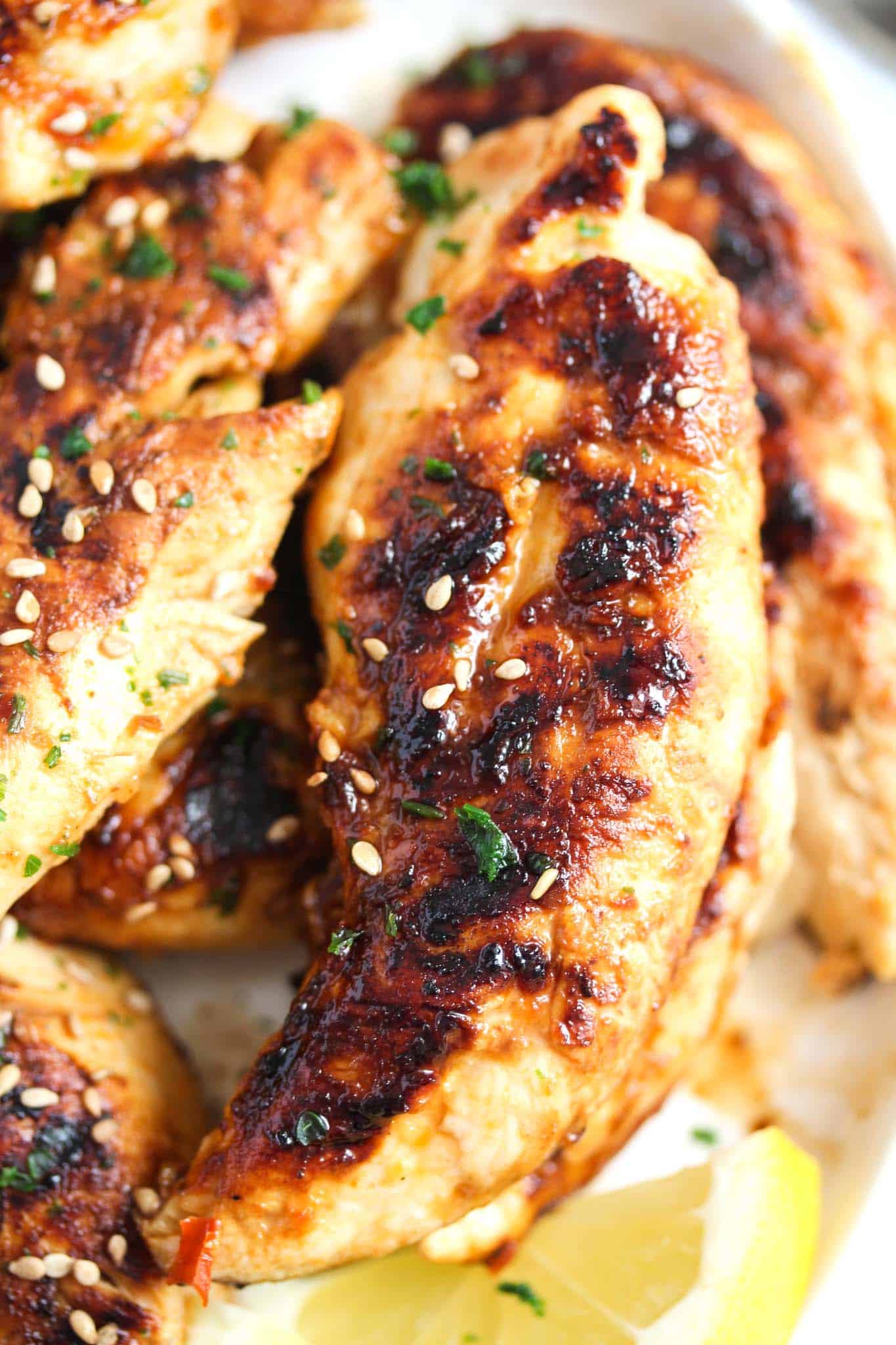 close up image of one grillled chicken tenders shiny and charred.
