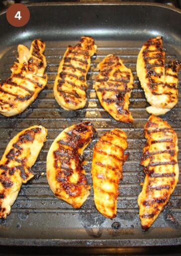 grilled chicken tenders with charred marks in a grill pan.