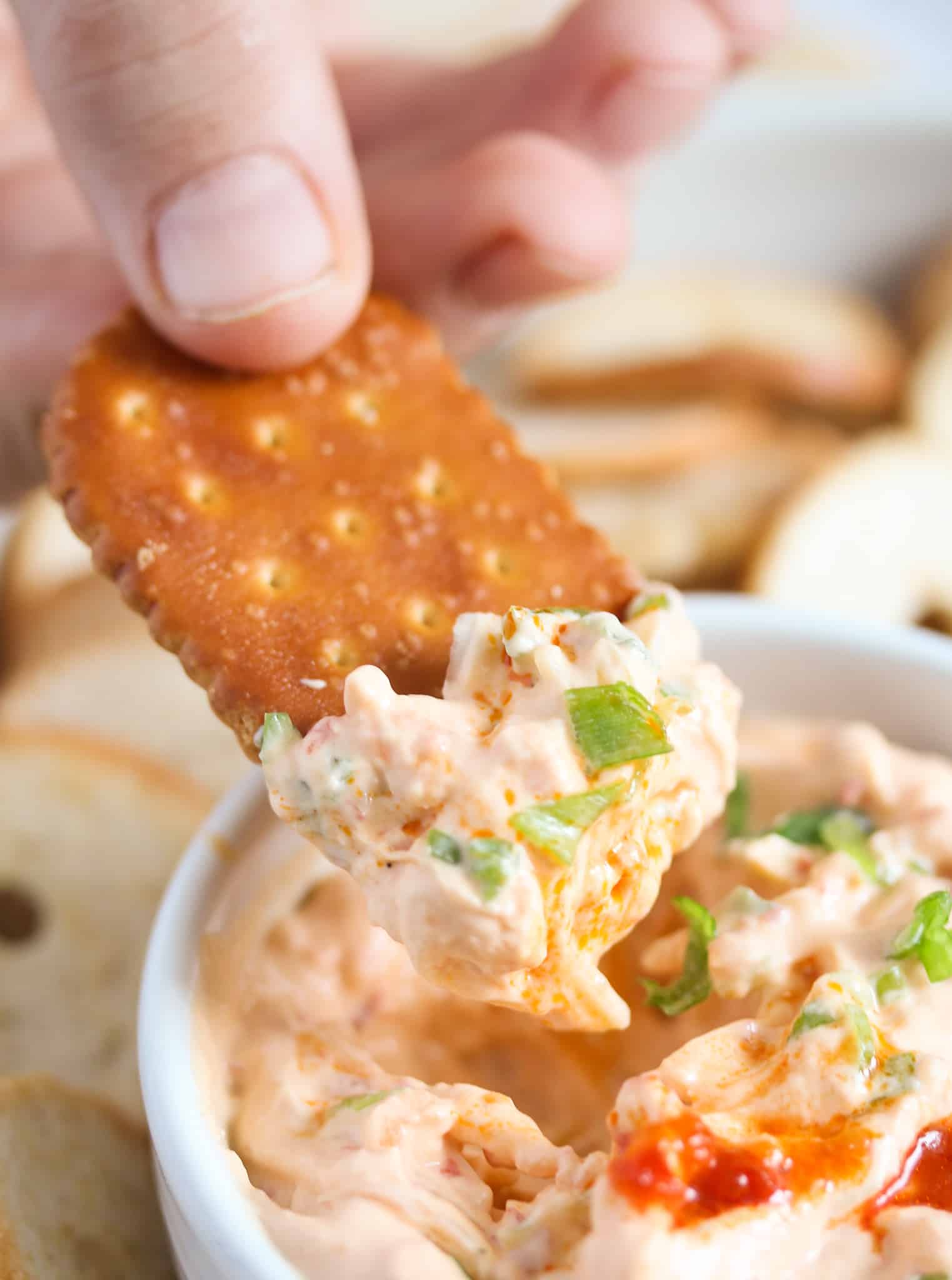 child's hand dipping cracker in peri peri dip.