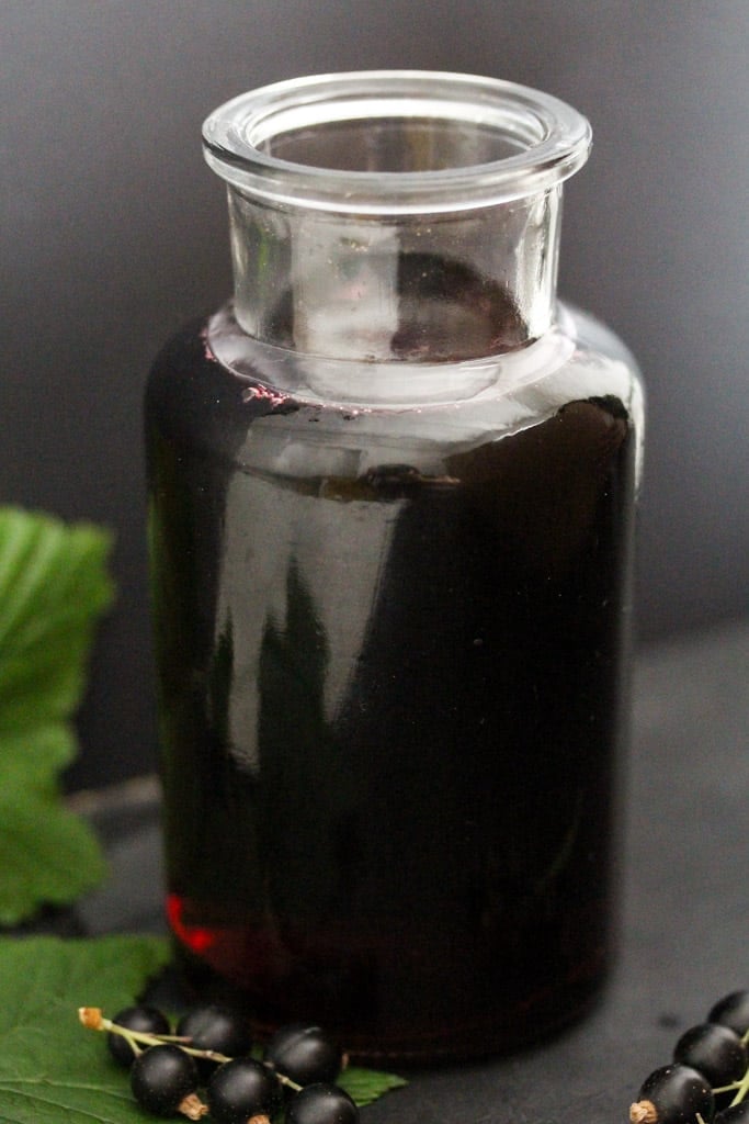 homemade dark red homemade syrup in a small bottle.
