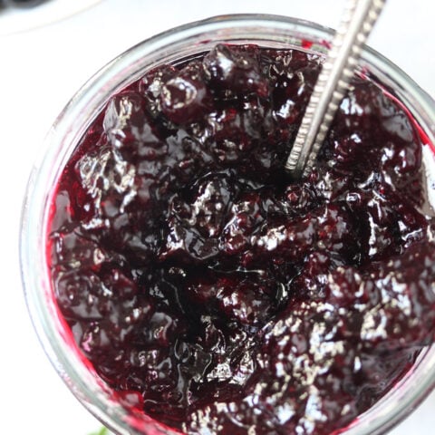 jam in a jar with a spoon in it overhead view.