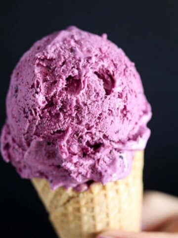 close up of scooped black currant ice cream in a cone.