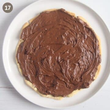spreading chocolate buttercream on a cake layer.