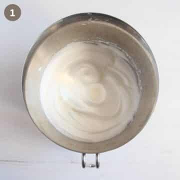 beaten egg whites in a metal bowl.