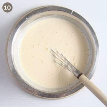 whisking heated egg and sugar mixture in a metal bowl.