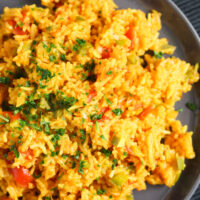 spicy rice on a black plate close up.