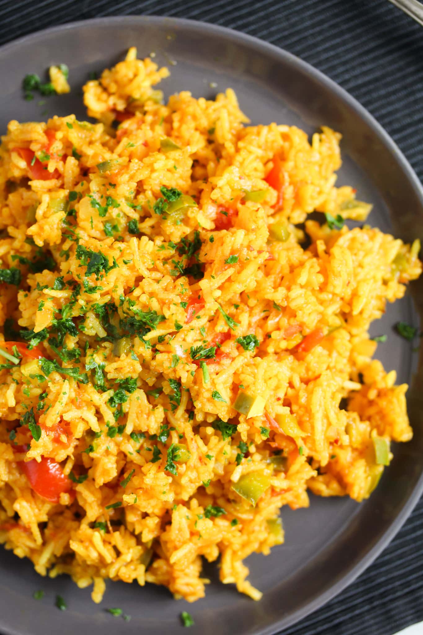 spicy rice on a black plate close up.