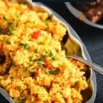 pinterest image of spiced rice on a platter with a spoon in it.