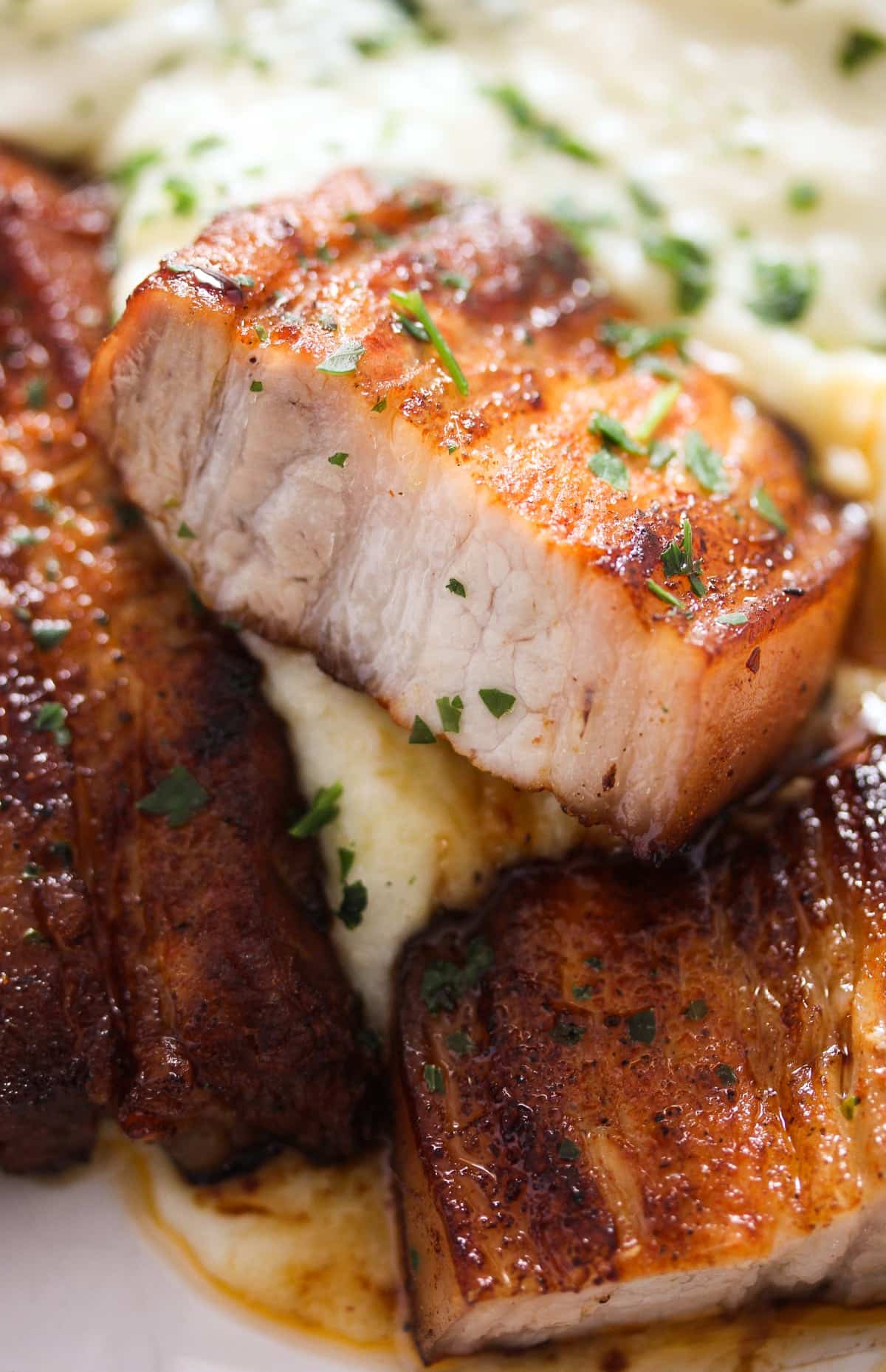 pork belly strips sliced and served with mashed potatoes.