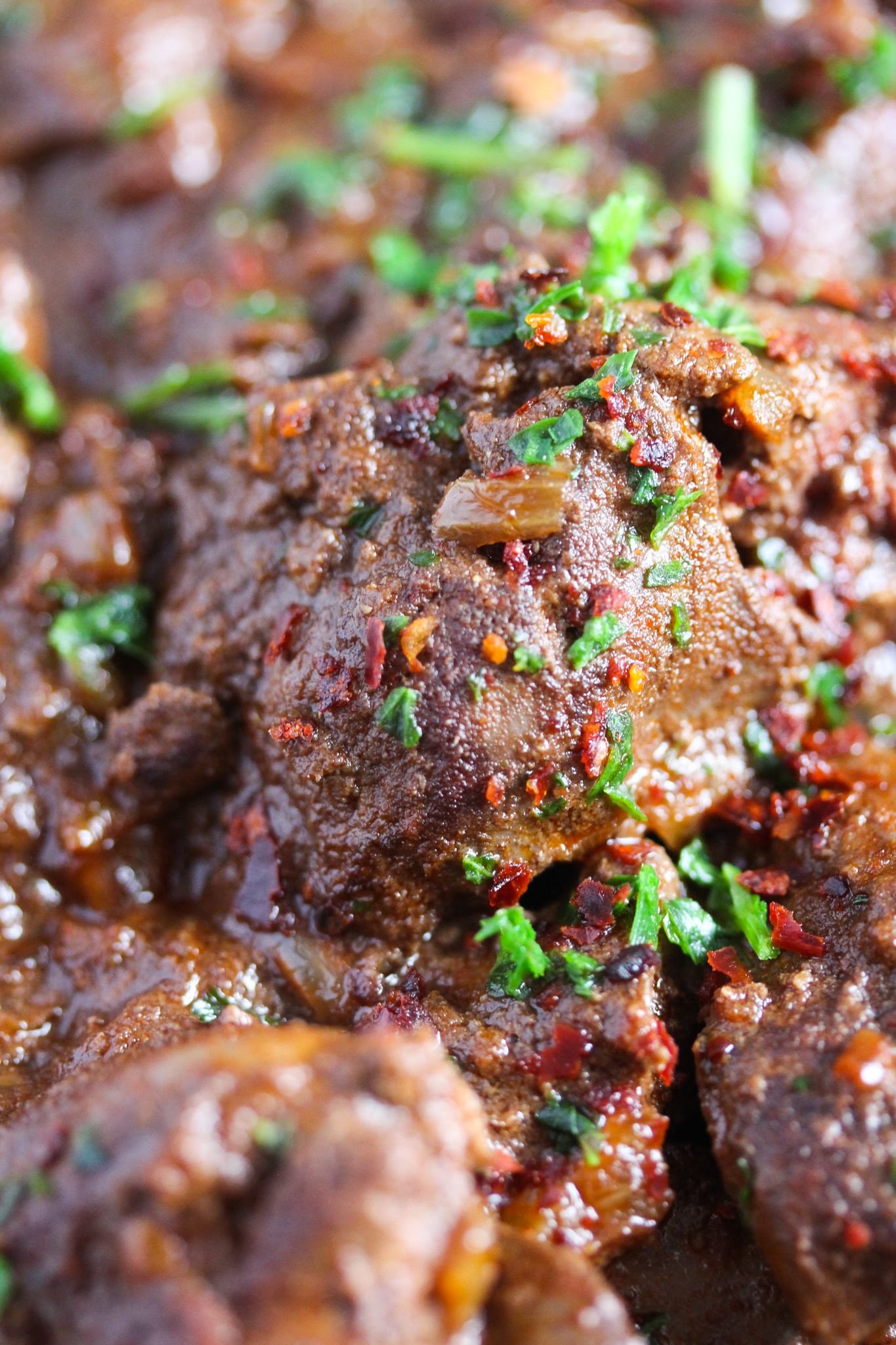 close up spicy livers sprinkled with chili and parsley.