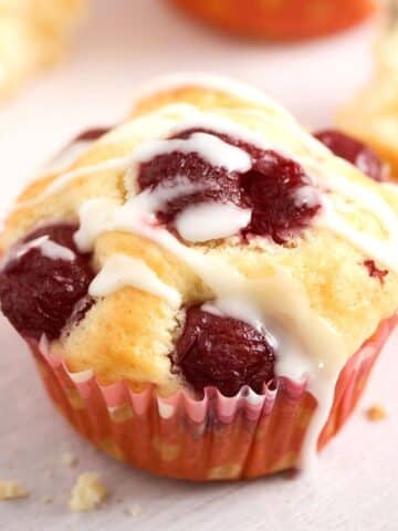 one quark muffin topped with cherries and icing.