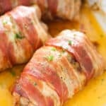 close up rolled up meat with bacon and sprinkled with parsley.