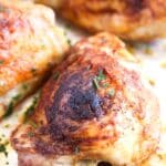pinterest image of baked thighs sprinkled with parsley.