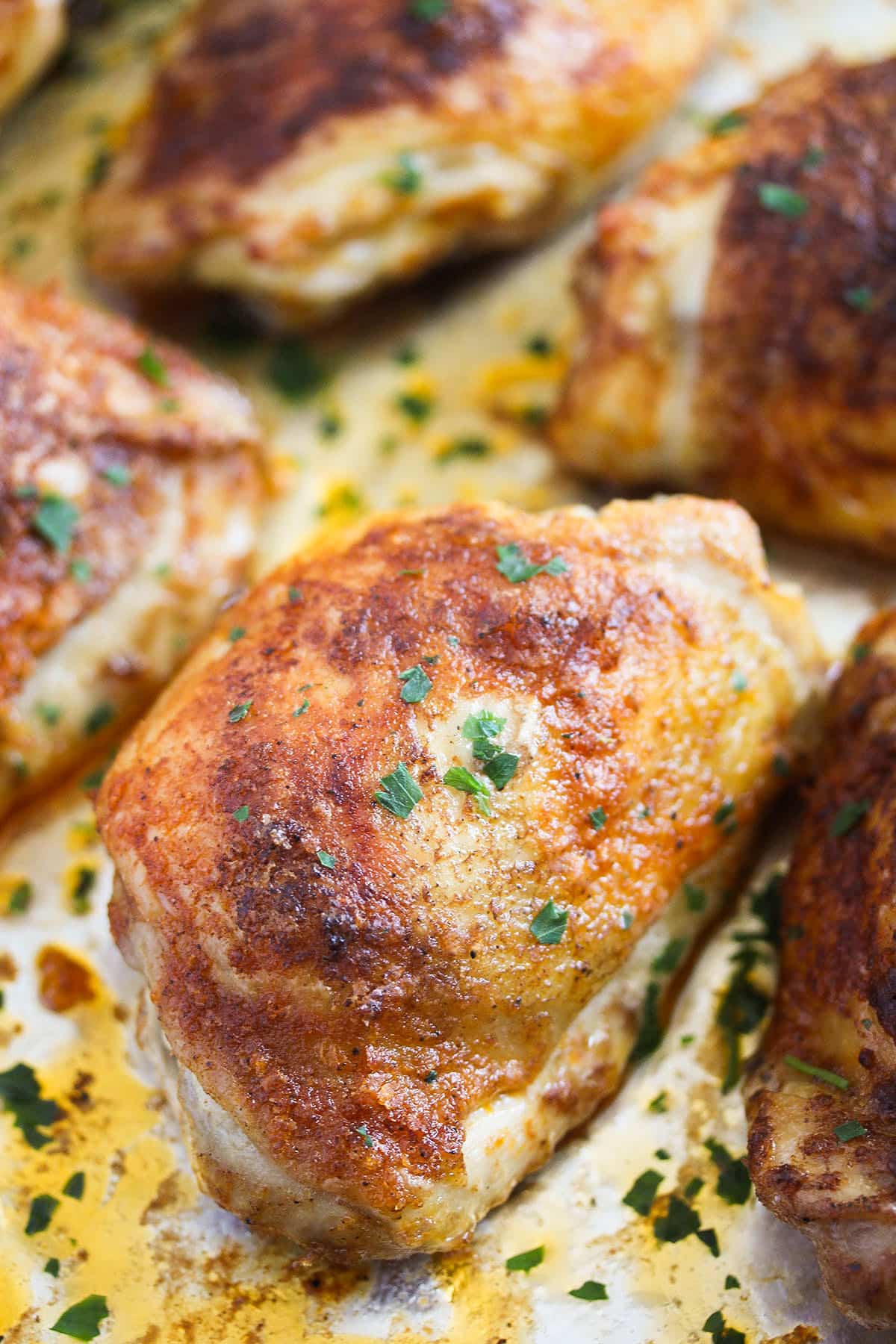 one chicken thigh baked from frozen and sprinkled with parsley.