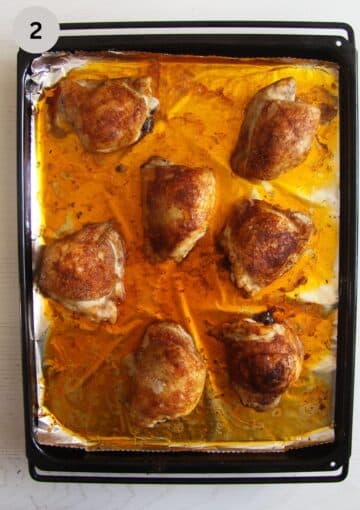 baked thighs cooked from frozen in a pool of juices on a baking tray.
