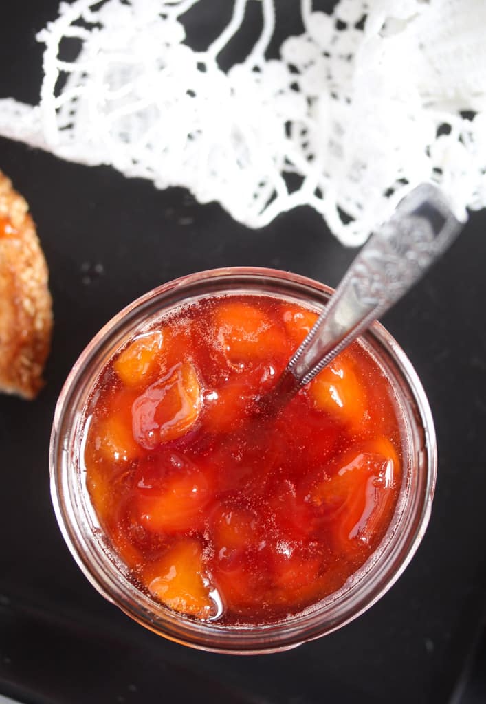 chunky peach preserves in a small jar overhead view.