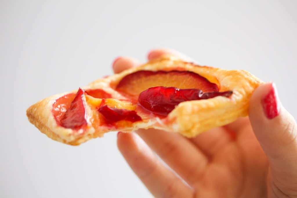 girl's hand holding a small pastry.