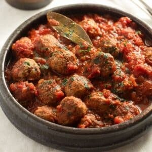 spanish meatballs in sauce in a traditional serving bowl.