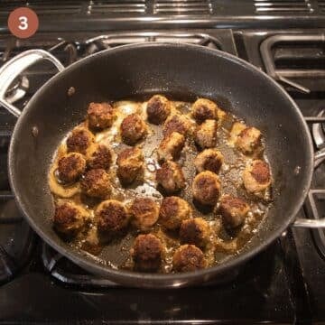 little spanish meatballs browning in a large saucepan.
