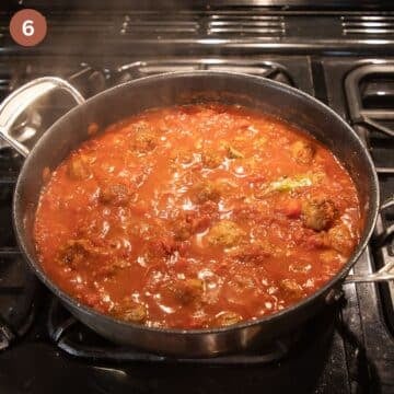 simmering meatballs in tomato sauce for making tapas.