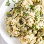 close up creamy rice sprinkled with parsley.
