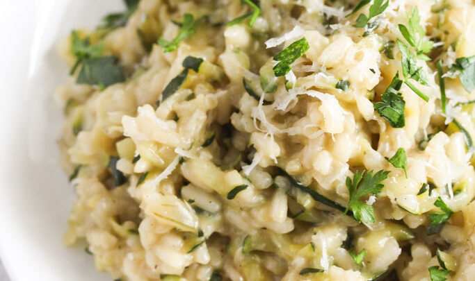 close up creamy rice sprinkled with parsley.