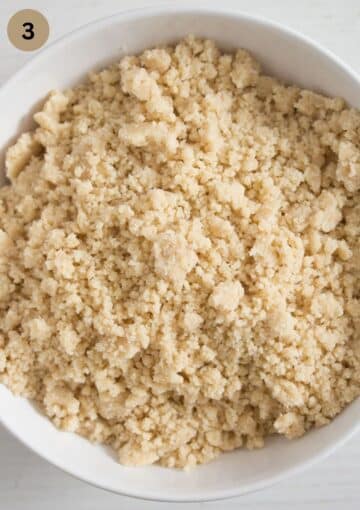 fresh streusel with butter, sugar and flour in a bowl for topping a plum cake.