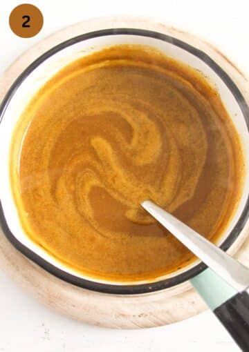 stirring pumpkin juice with a spoon in a small saucepan.