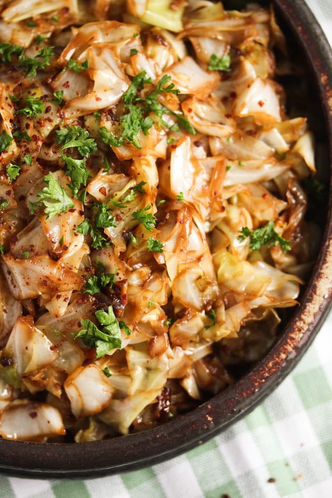 close up of fried pointed cabbage in a brown rustic bowl.