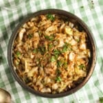 cooked sweetheart cabbage in a bowl on a striped kitchen cloth.