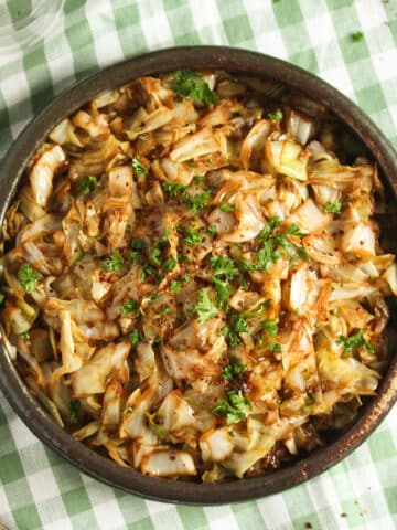 cooked sweetheart cabbage in a bowl on a striped kitchen cloth.