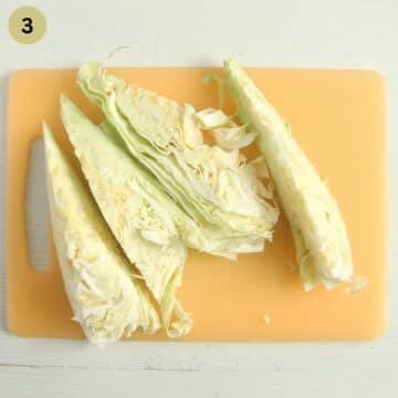 sweetheart cabbage cut into quarters on a cutting board.