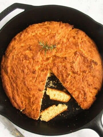 golden cast iron cornbread and two cut slices.