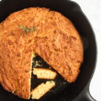 cast iron pan with golden brown cornbread in it.