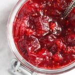 close up ruby red homemade cranberry sauce in a jar.