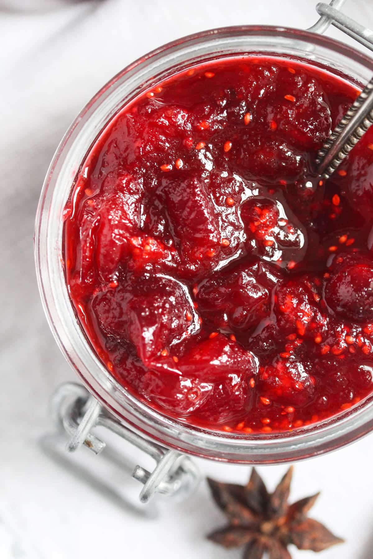 close up ruby red homemade cranberry sauce in a jar.